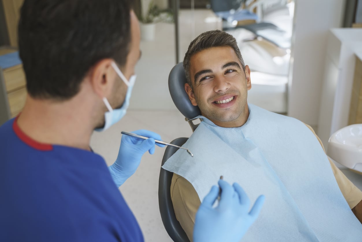Man speaking with his dentist ahead of an examination
