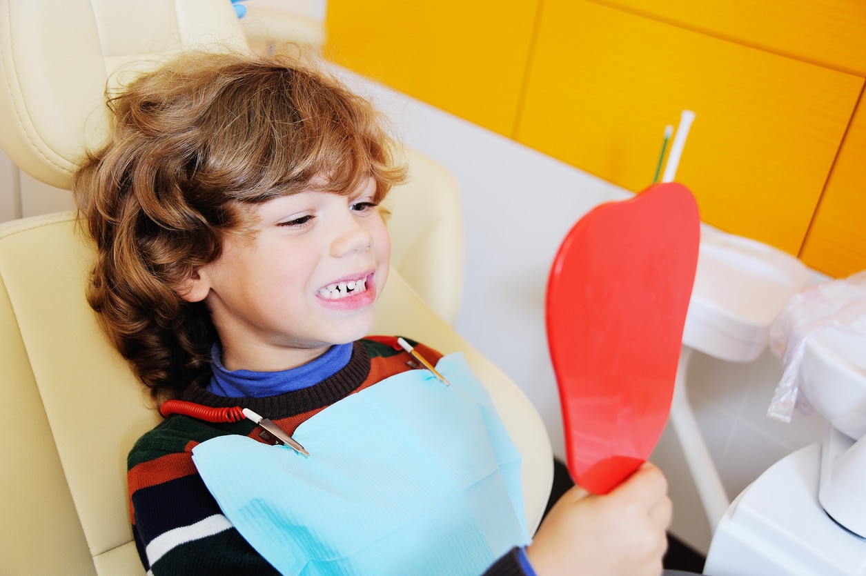 Boy looking at his teeth in a dental chair