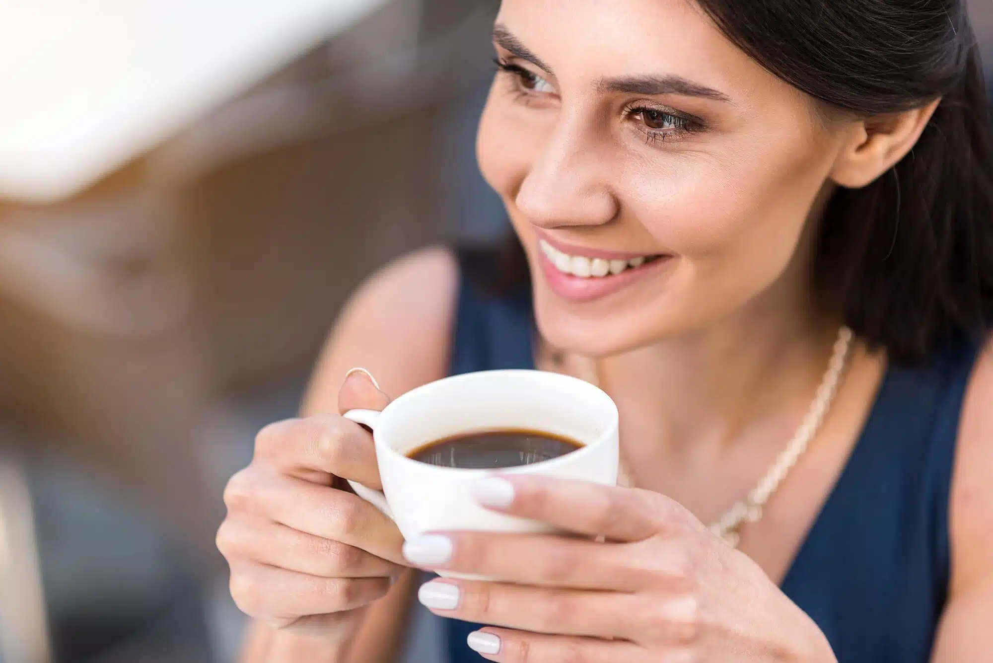 Girl sipping coffee after teeth whitening detroit