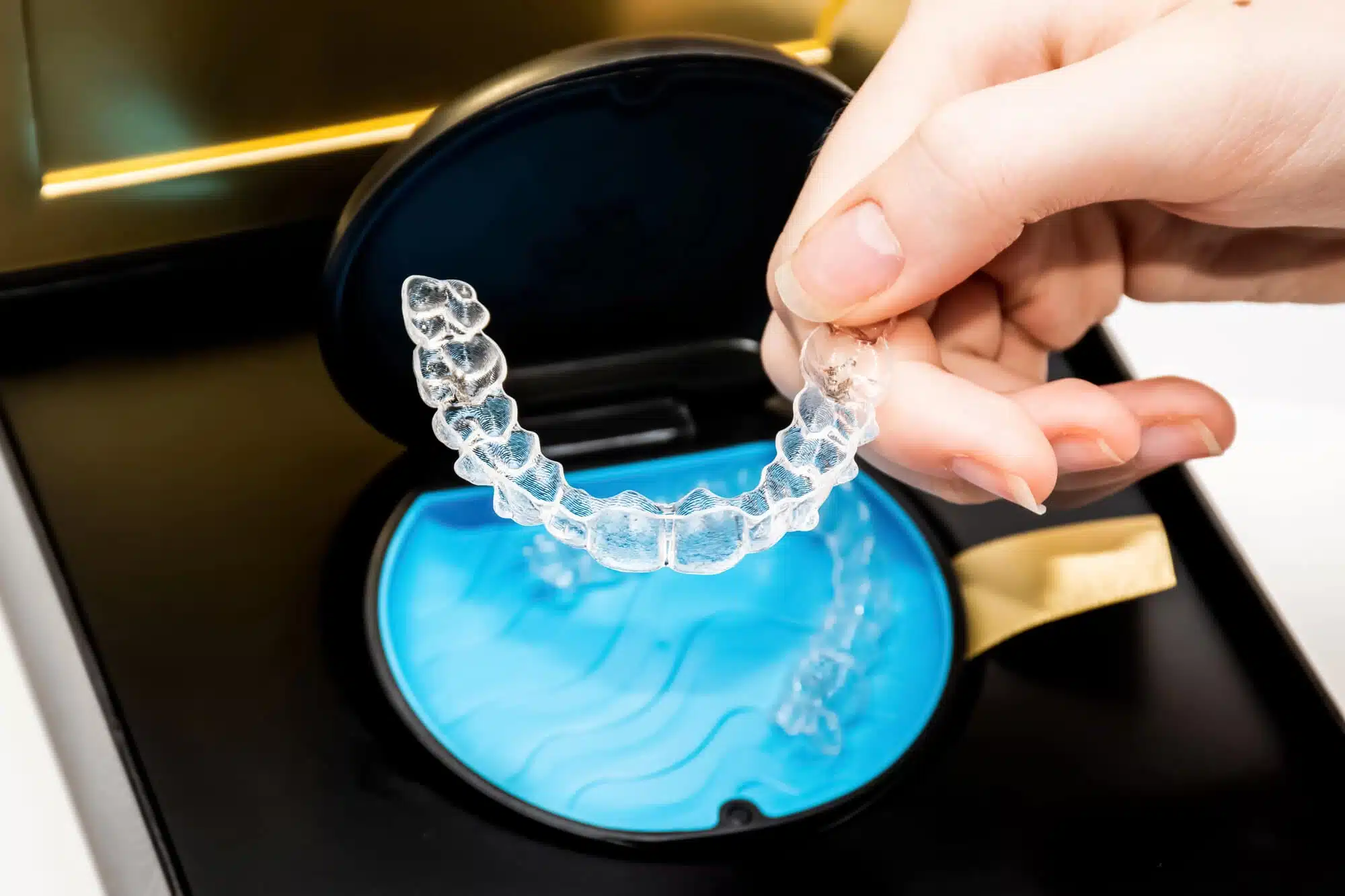 person putting Invisalign novi inside the case